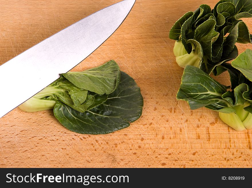 Cutting a bokchoy cabbage on a cutting board. Cutting a bokchoy cabbage on a cutting board