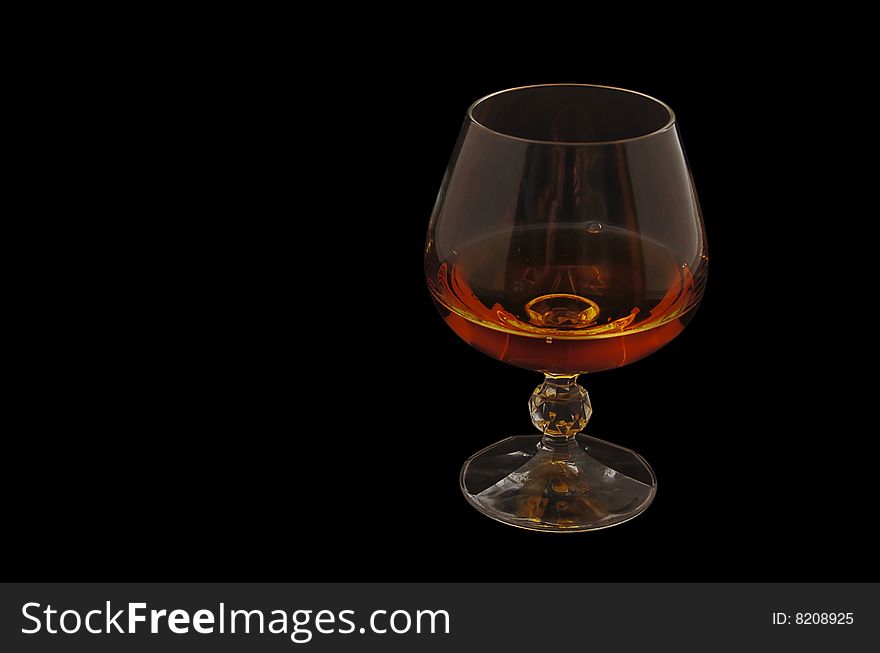 Wineglass with cognac isolated over black