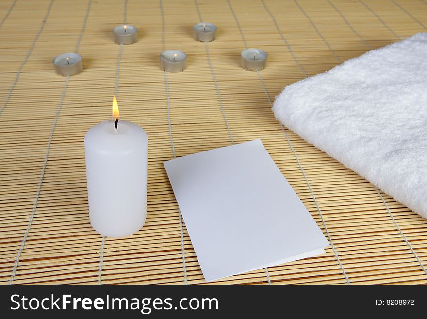 Spa objects. Candles, towel and paper.