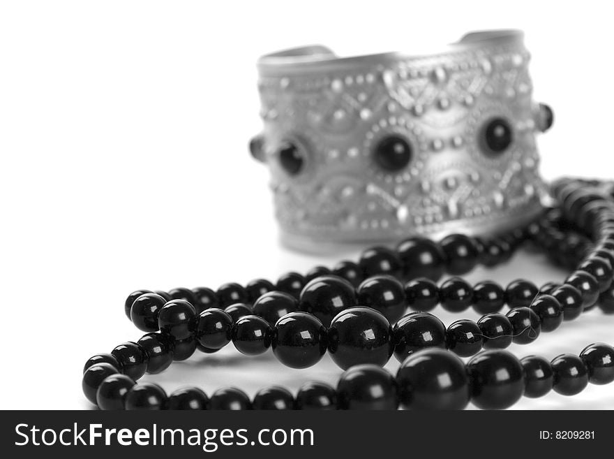 Bracelet and black necklace closeup on a white background