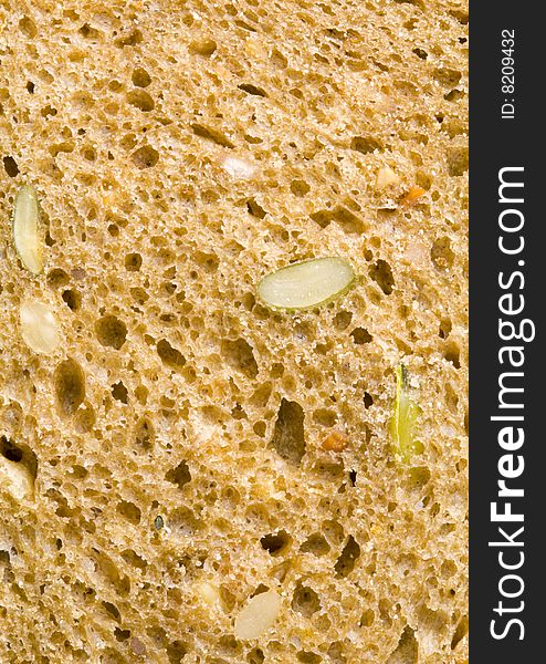 A close up of the texture of a slice of brown bread. A close up of the texture of a slice of brown bread