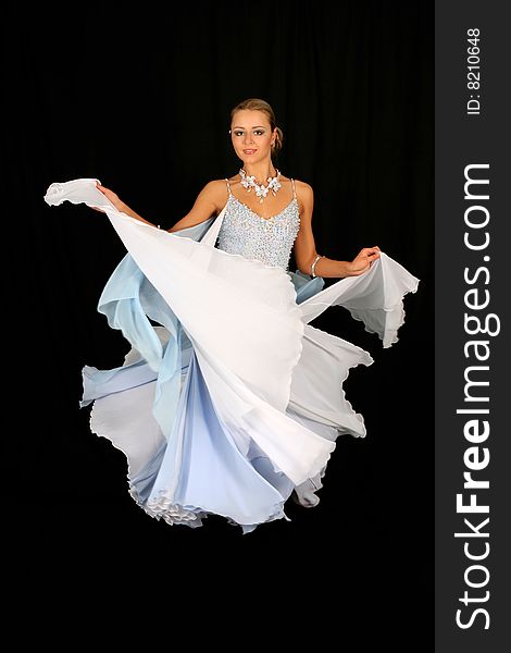 Blonde in dance in classical blue-white dress against black background