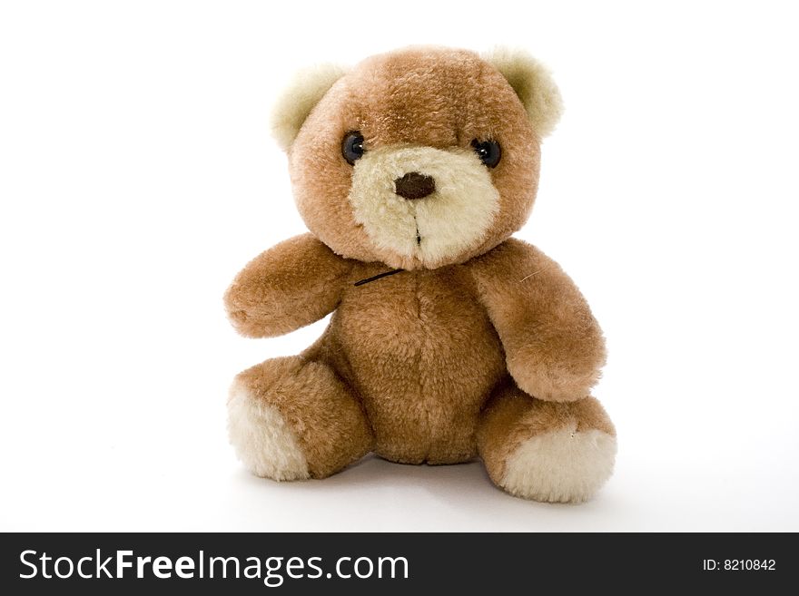Plush bear sits against the white background. Plush bear sits against the white background