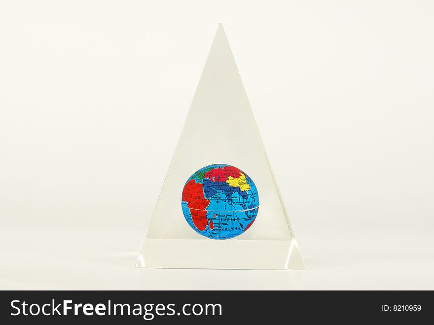 Color globe of the earth with visible countries and Indian Ocean inside a glass pyramid. Color globe of the earth with visible countries and Indian Ocean inside a glass pyramid