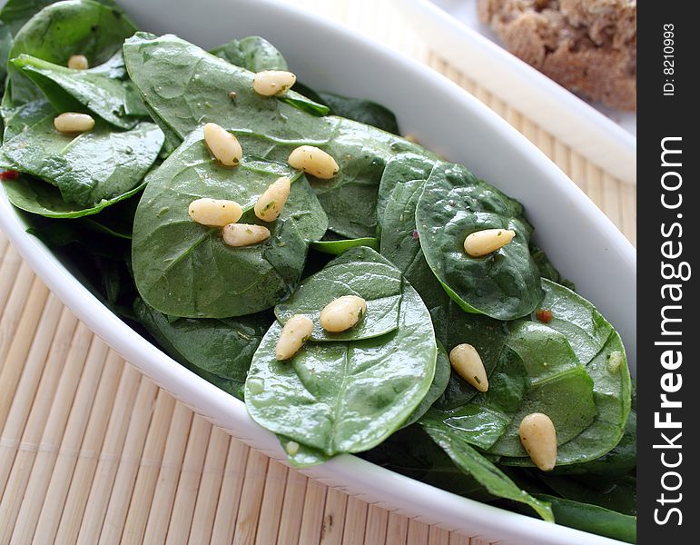 A fresh salad of spinach with pine seeds