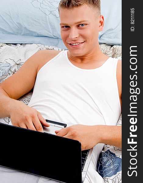 Man keeping laptop on his stomach in bed. Man keeping laptop on his stomach in bed