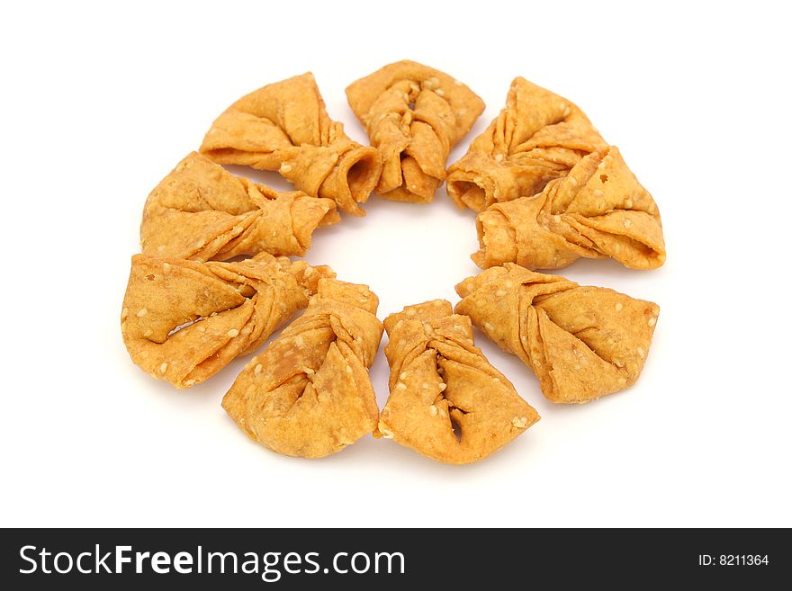 Sesame ribbon cookie arranged in round shape on white background.
