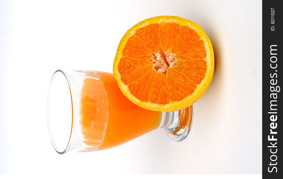 Cut Orange with with a half full glass of juice. Cut Orange with with a half full glass of juice