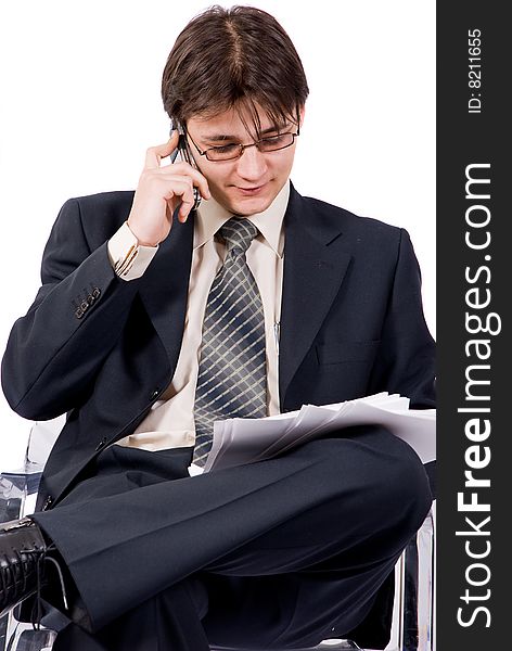 Young businessman looks documents and calling by cellular phone. Over white