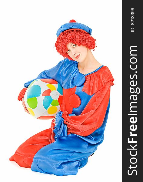 Young woman clown sitting on white background with a ball. Young woman clown sitting on white background with a ball