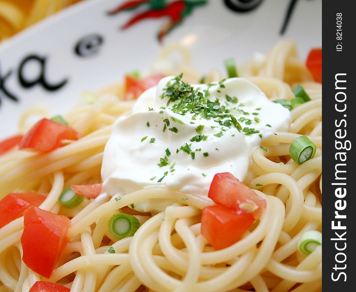 Fresh italian pasta with tomatoes and spring-onions