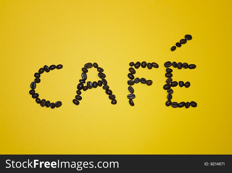 Cafï¿½ written with beans on yellow background.