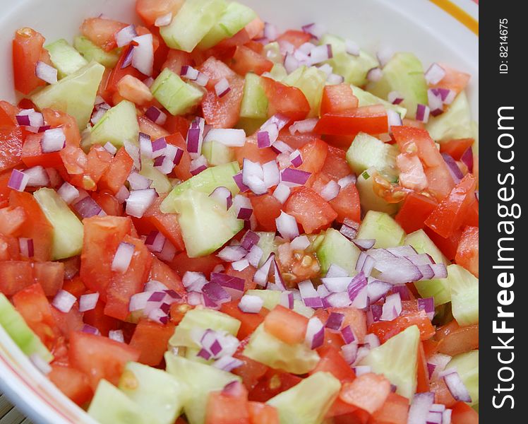 A fresh salad of tomatoes and cucumbers with onions