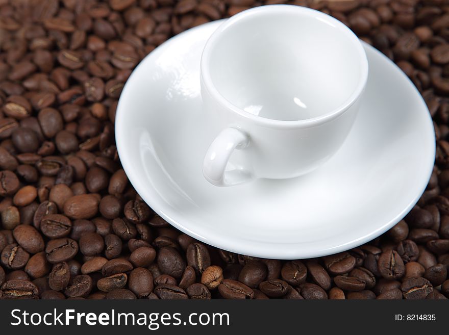 The white coffee cup standing on coffee beans. The white coffee cup standing on coffee beans