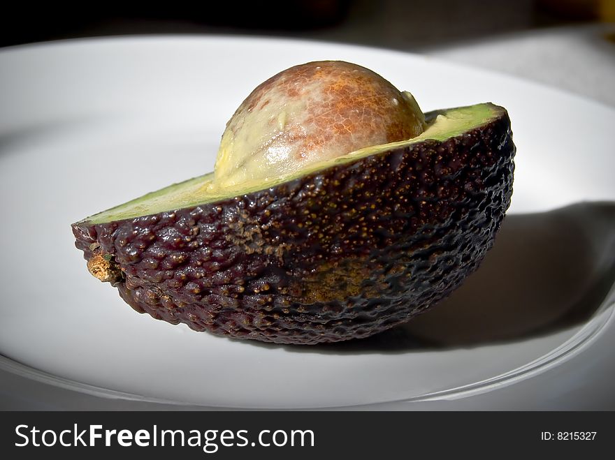 Fresh .Textured.With dew droplets on the skin.Half avocado with seed being exposed. Fresh .Textured.With dew droplets on the skin.Half avocado with seed being exposed.