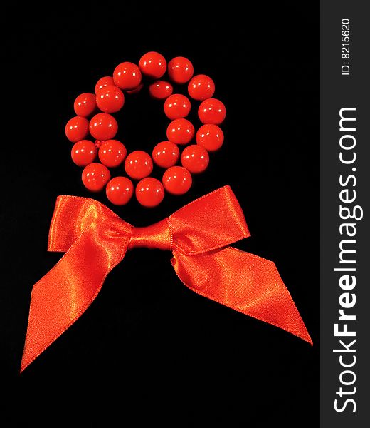 Red bow and beads on the black background