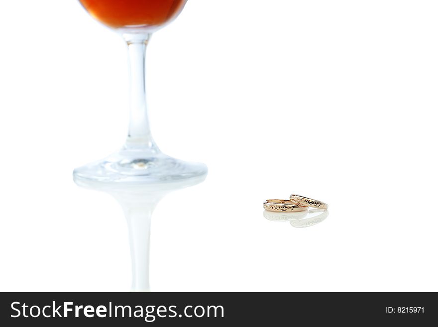 Isolated red wine cup with wedding rings. Isolated red wine cup with wedding rings