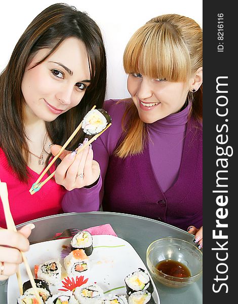 A pretty young  womans eating salmon sushi with chopsticks. A pretty young  womans eating salmon sushi with chopsticks