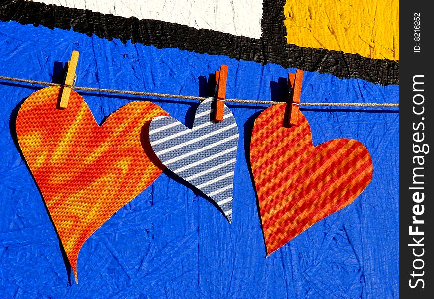 Three textil hearts on front of a paint wall