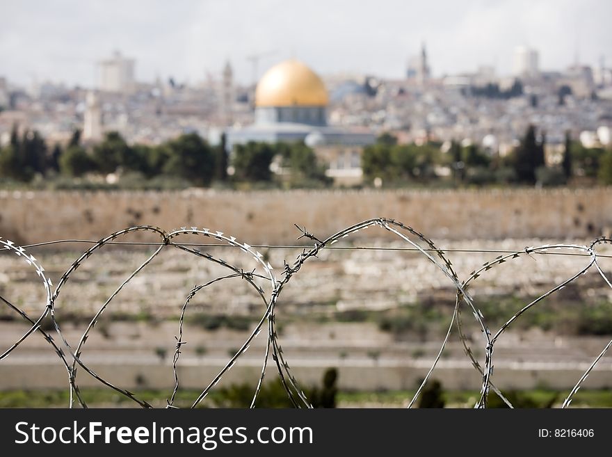 Jerusalem Old City with The Dome of the Rock. View from Olive Mountain over razor wire.