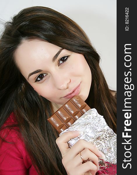 Beautiful young  woman eating a chocolate