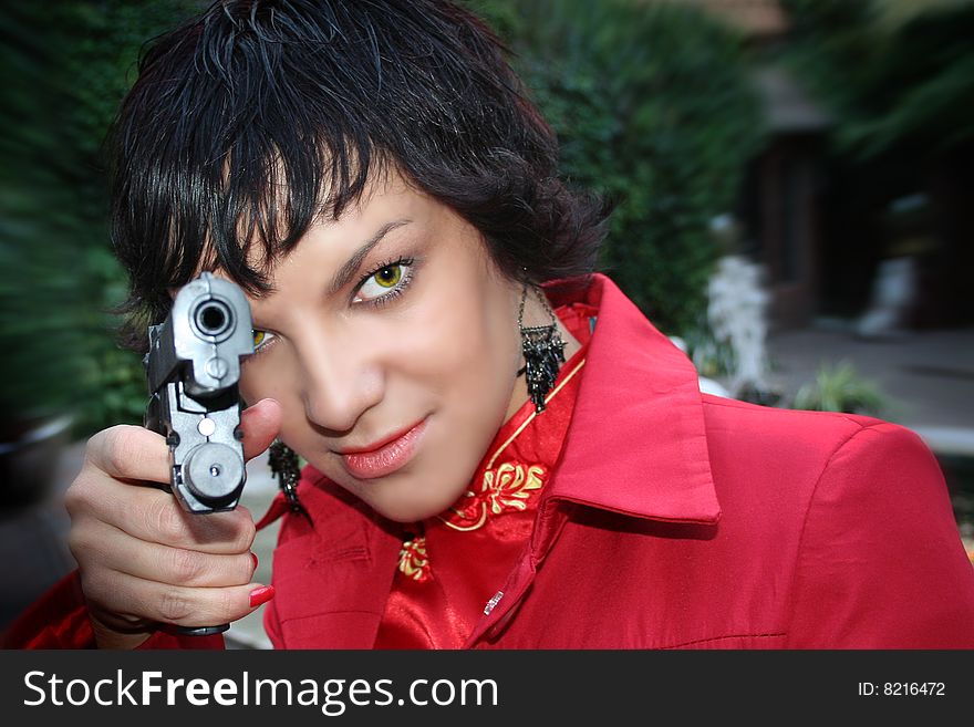 attractive brunette woman with gun aiming at camera on a dynamic background. attractive brunette woman with gun aiming at camera on a dynamic background