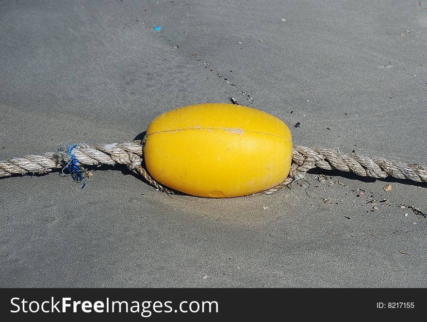 Yellow float on beach sand