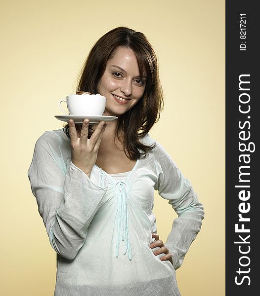 Young laughing woman with long brown hair and a cup of coffee. Young laughing woman with long brown hair and a cup of coffee