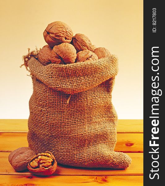 Sack of walnuts on a table made of wood