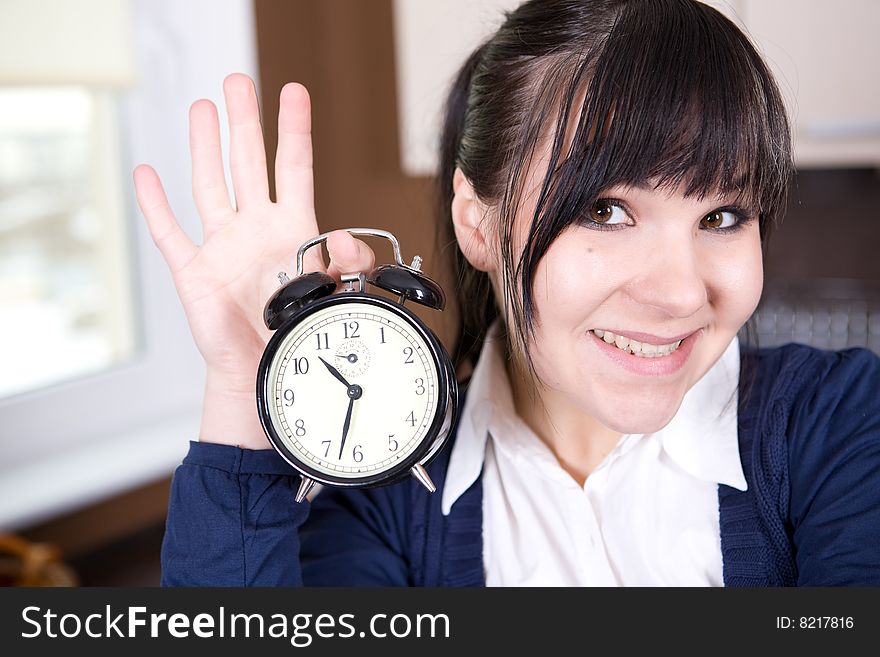 Attractive brunette and tired woman with clock