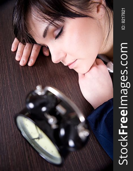 Attractive brunette and tired woman with clock
