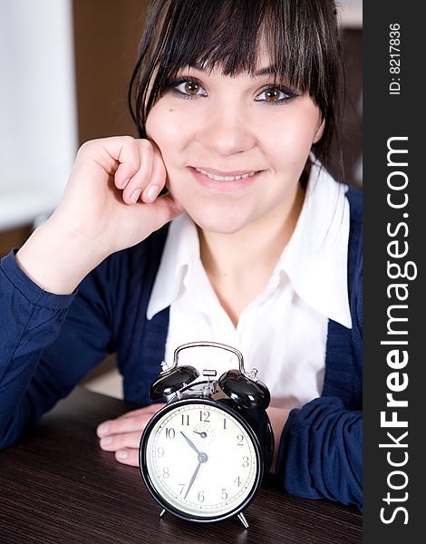 Attractive brunette and tired woman with clock