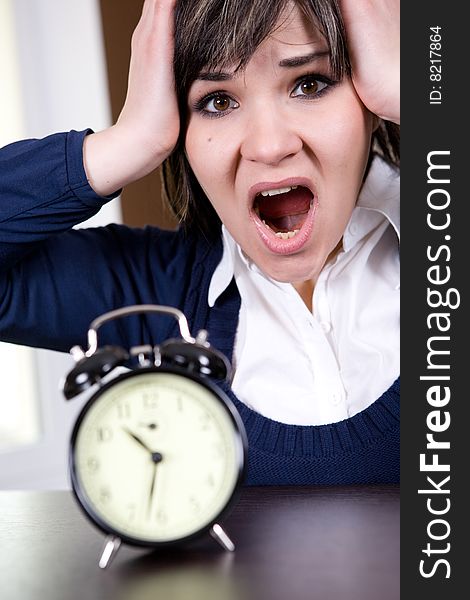 Attractive brunette and tired woman with clock