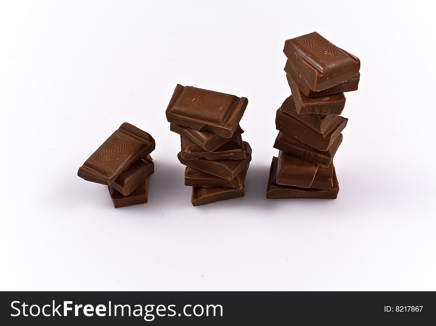 Stack of chocolate chunks isolated on white. Illustration of sweets consuption growth rate.