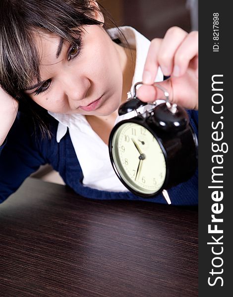 Attractive brunette and tired woman with clock