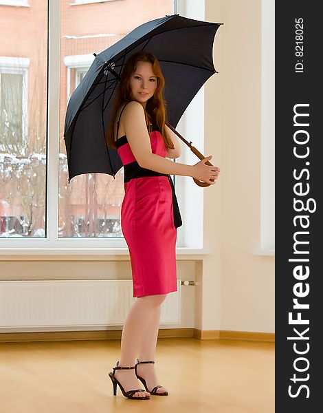 Beautiful young woman with umbrella in room. Beautiful young woman with umbrella in room