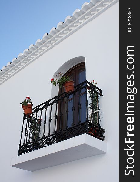 Ornate balcony with plants in the village of Frigiliana in Spain. Ornate balcony with plants in the village of Frigiliana in Spain.