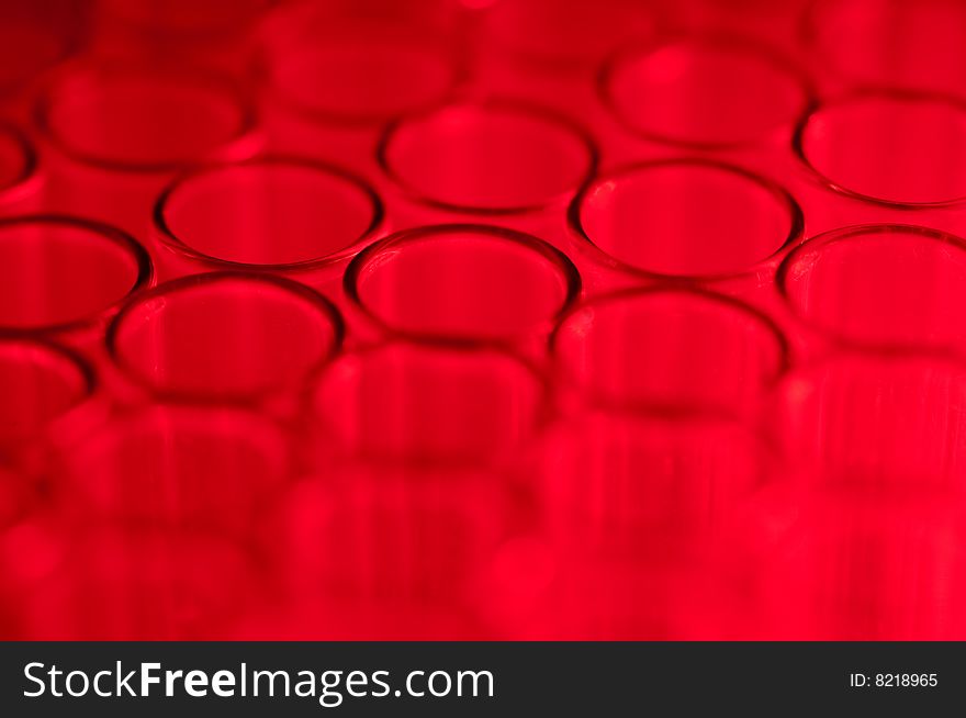 Shallow focus close-up of empty glass test tubes in red