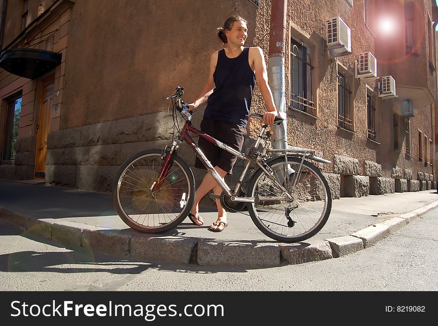 Smiling young man with the bike