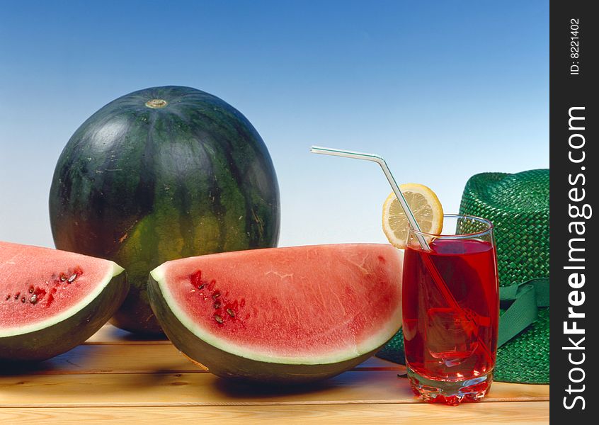 Watermelon with cocktail on a table made of wood