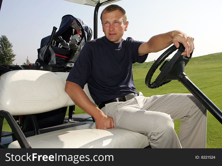 A golfer driving the golf carts