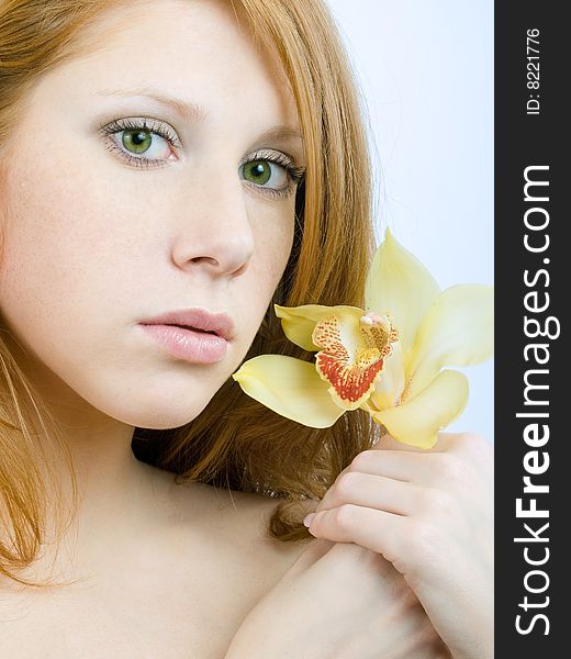 Redheaded girl with an orchid at hands. Redheaded girl with an orchid at hands