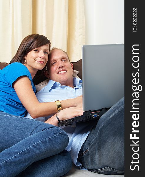 Young couple on the couch at home looking at the laptop!. Young couple on the couch at home looking at the laptop!