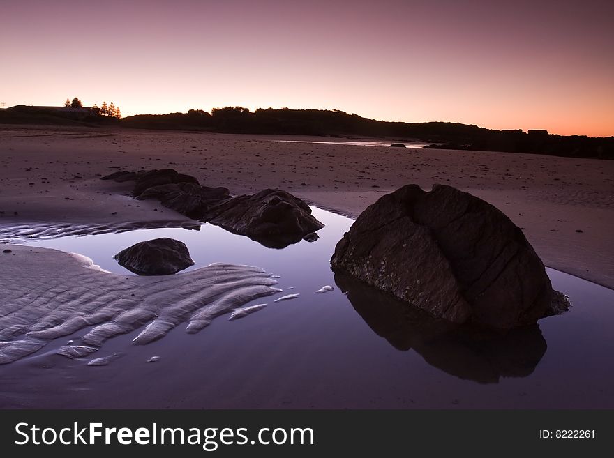 Beautiful beach and reflected stone formation taken in Anna Bay, NSW, Australia during twilight conditions.