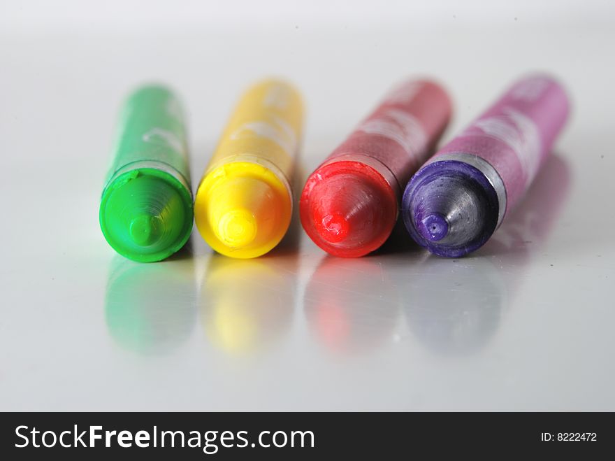 Crayons in different colors lying on a shiny desk. Crayons in different colors lying on a shiny desk