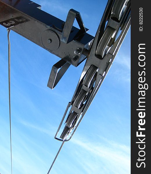 Unique view of chairlift tower at a ski area.  Blue sky and a great view of the pulleys suspending you in the air.

Brrr - Winter is coming!