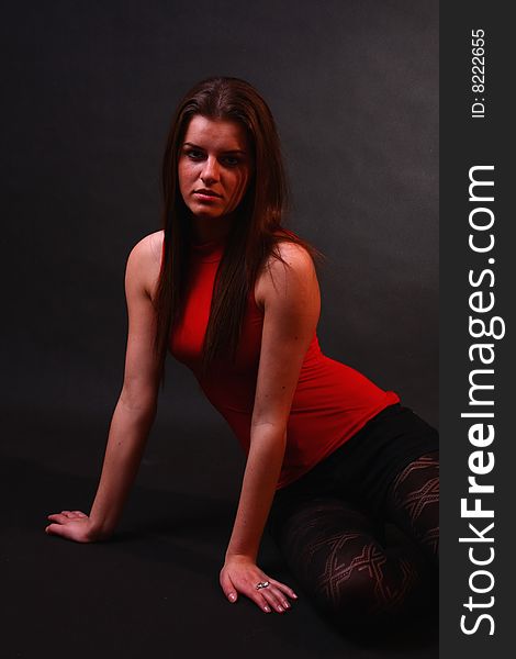 Young attractive girl in the soft studio light sitting on the floor. Young attractive girl in the soft studio light sitting on the floor