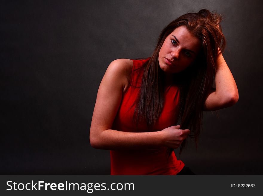 Young attractive girl in the soft studio light sitting on the floor. Young attractive girl in the soft studio light sitting on the floor