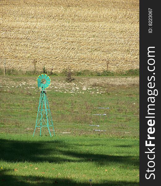 Green windmill against harvested field. Green windmill against harvested field