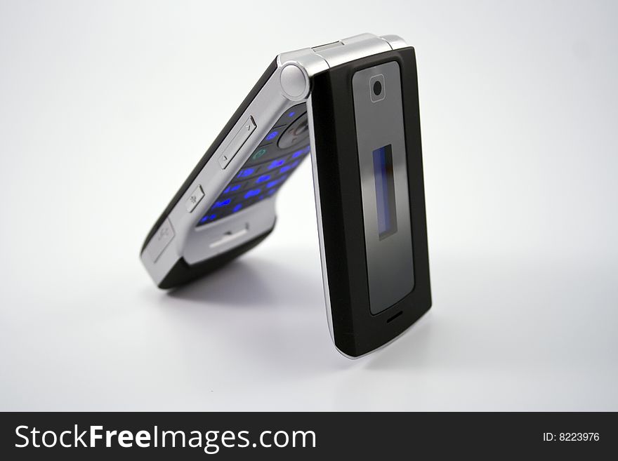 An image of a black cell phone standing up with blue glowing buttons.